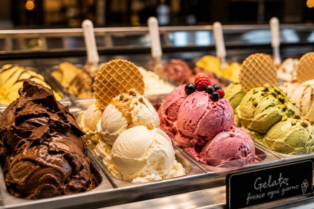 Trays of chocolate, vanilla, berry and pistachio gelato in a display counter